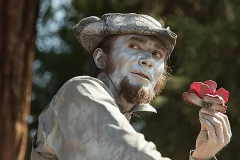 living statue: a street performer who poses like a statue, usually with realistic statue-like makeup, sometimes...