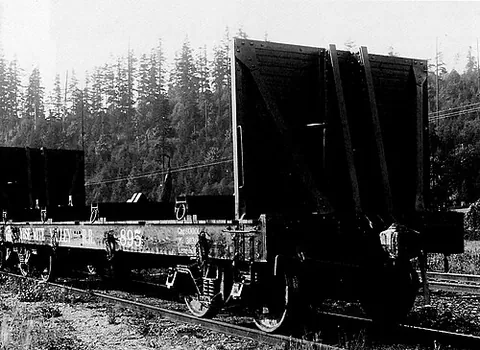 log car: a railroad car designed and used for transporting wooden logs
