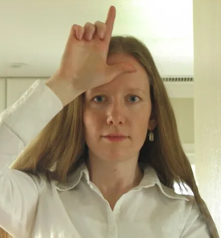 loser sign: a gesture made by placing the hand in the L shape near the forehead; used to signify that someone...