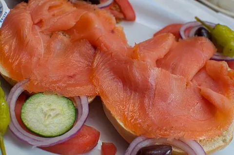 lox: salmon that is cured in brine and then smoked at a low temperature so that the flesh remains...