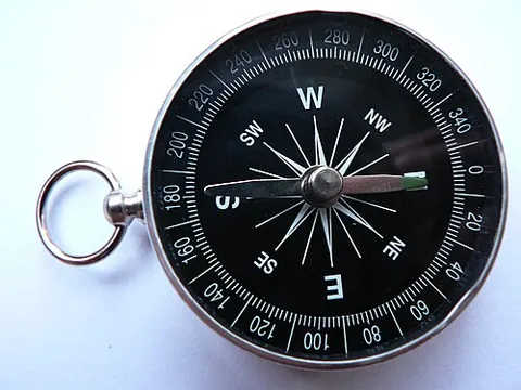 magnetic compass: an instrument containing a freely suspended magnetic element which displays the direction of the...