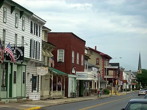 main drag: the main street of a town or suburb, or the principal highway passing through a rural area