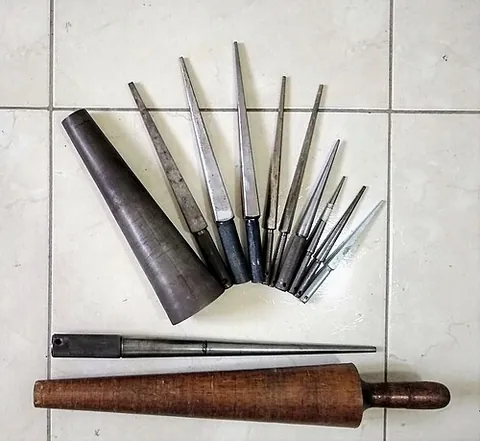mandrel: a round object used as an aid for shaping a material, e.g. shaping or enlarging a ring, or bending...