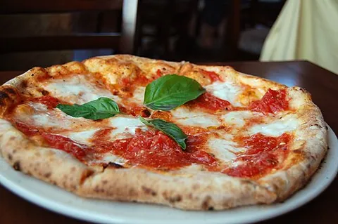 margherita pizza: the traditional Neapolitan pizza, topped with basil, tomatoes and fresh mozzarella