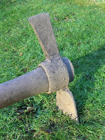 mattock: an agricultural tool whose blades are at right angles to the body, similar to a pickaxe