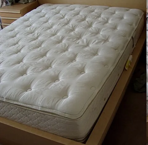 mattress: a pad on which a person can recline and sleep, usually having an inner section of coiled springs...