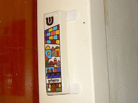 mezuzah: a piece of parchment inscribed with specific Hebrew verses from the Torah (Deuteronomy 6:4–9 and...