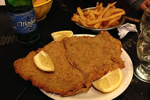 milanesa: a thin slice of beef or another meat, dipped into beaten eggs, seasoned with salt and other...