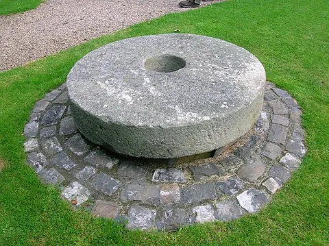 millstone: a large round stone used for grinding grain
