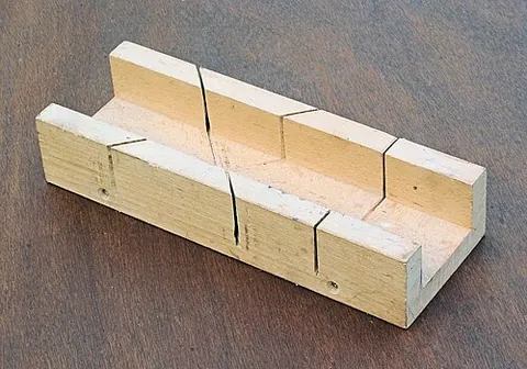 mitre box: a wood working appliance used to guide a handsaw or backsaw for making precise cuts, usually 45°...