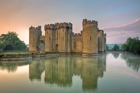 moat: a deep, wide defensive ditch, normally filled with water, surrounding a fortified habitation