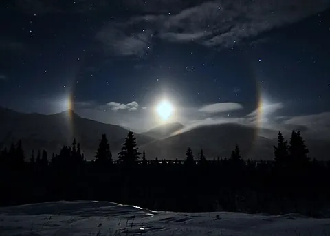moon dog: a bright, circular spot, sometimes seen on a lunar halo, caused by refraction through ice crystals