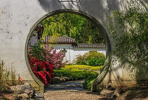 moon gate: a circular opening in a garden wall that acts as a pedestrian passageway and is a traditional...