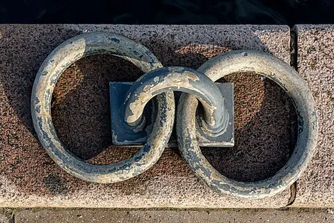 mooring ring: a ring of metal attached to a dock to which boats may be attached by a rope