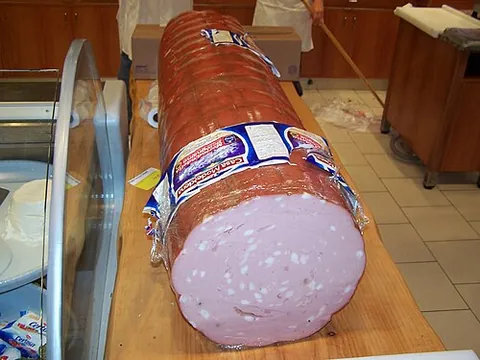 mortadella: a smooth-textured Italian pork sausage with lumps of fat, flavoured with spices; eaten cold