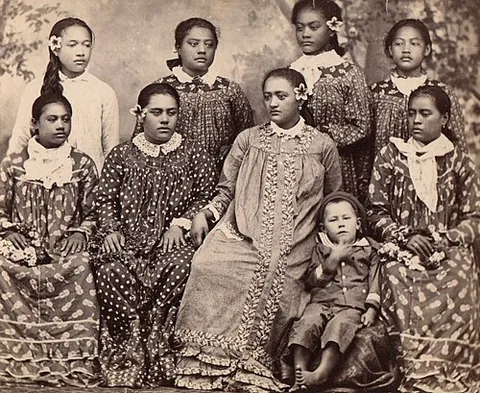 mother hubbard: a long, wide, loose gown with long sleeves and a high neck originally introduced by Christian...