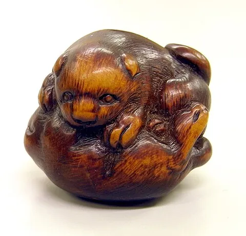 netsuke: a small, often collectible, artistic carving characterized by an opening or two small holes (紐通し...