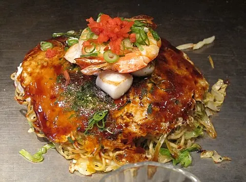 okonomiyaki: a Japanese style of savoury pan-fried thick pancake including a mixture of vegetables and beef,...