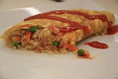 omurice: a Japanese dish consisting of an egg omelette with rice mixed with ketchup in the center