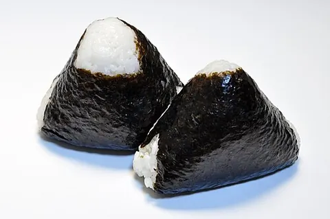 onigiri: a Japanese food made by putting ingredients into white rice, wrapping the outside with laver, and...