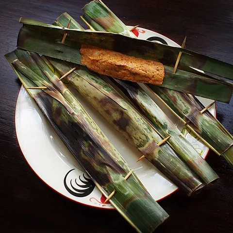 otak-otak: grilled fish cake wrapped inside a banana leaf; a popular snack food in Southeast Asia,...