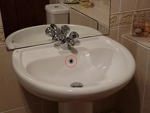 overflow hole: the hole in a sink that prevents it overflowing by diverting excess water to the drain