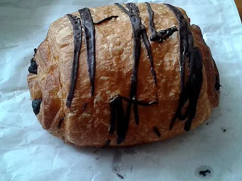 pain au chocolat: a French snack consisting of a pastry, normally similar to a croissant, with chocolate inside