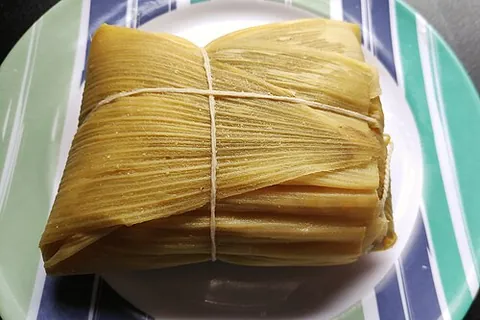 pamonha: a traditional Brazilian food, a dumpling made from sweetcorn and milk boiled wrapped in the husk,...