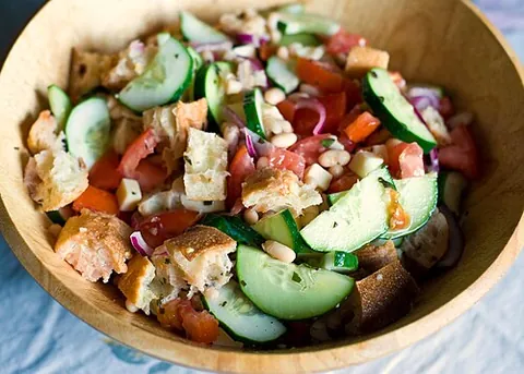 panzanella: a summer bread salad including sliced bread and fresh tomatoes, flavored with basil, olive oil and...