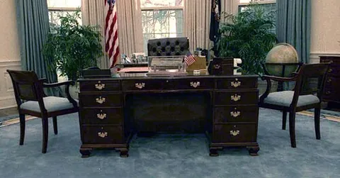 partners desk: a large pedestal desk designed for two people who work while facing each other, and having a deep...