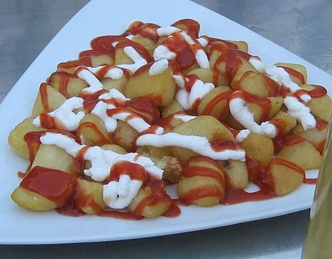 patatas bravas: a Spanish dish consisting of small pieces of potato fried in oil, with a spicy tomato sauce