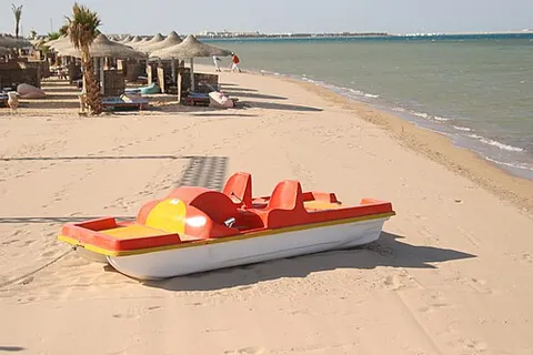 pedalo: a small boat propelled by pedals that directly turn external paddles, used for recreation