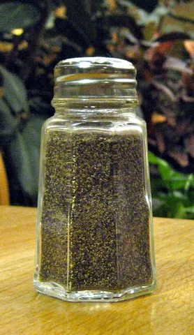 pepper shaker: a small container designed to hold pepper and facilitate sprinkling it on food for seasoning...