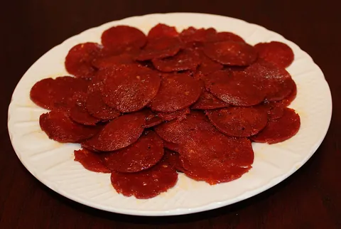 pepperoni: a spicy salami-style Italian-American sausage made from cured pork and beef seasoned with pepper