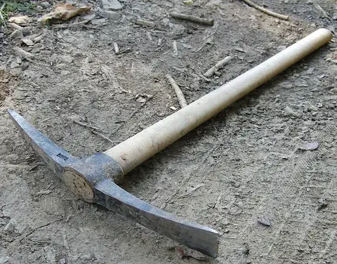 pickaxe: a heavy iron tool with a wooden handle; one end of the head is pointed, the other has a chisel edge