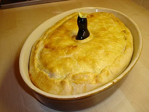 pie bird: a hollow ceramic device shaped like an upstretched bird with open beak, used for supporting or...