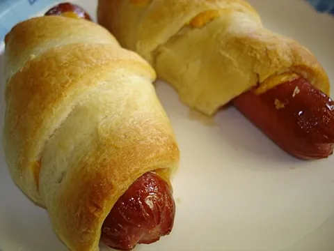 pig in a blanket: a small sausage, usually a short hot dog, wrapped in dough and baked
