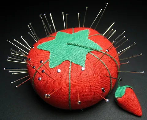 pincushion: a device, originally like a small, stuffed cushion, designed to have sewing pins and needles stuck...