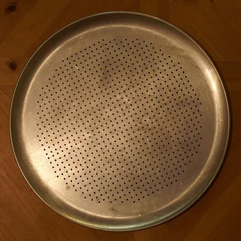 pizza pan: a pan specialized for making US-style pizzas, similar to a pie pan, cookie sheet, or paella pan,...