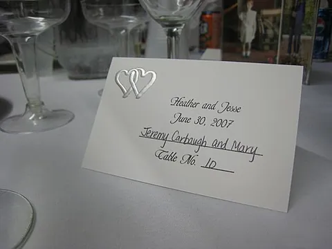 place card: a card set down at a table to inform a guest (named on the card) where they are to sit