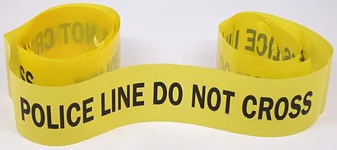 police tape: tape used as a police barricade, typically in order to restrict access to the scene of a crime