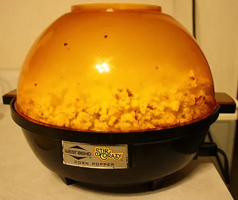 popcorn popper: a machine used to pop kernels or corn to make popcorn