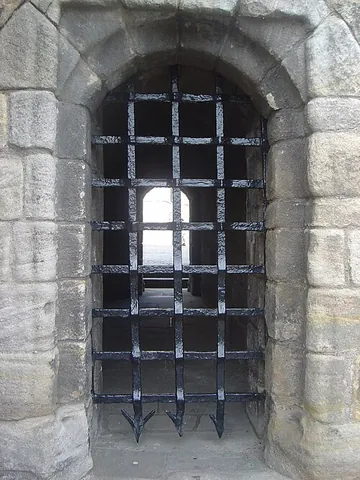 portcullis: a gate in the form of a grating which is lowered into place at the gateway of a castle, a fort, etc
