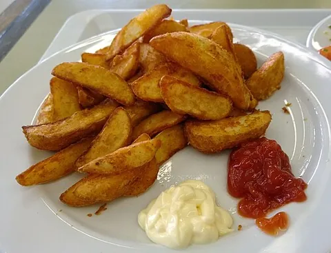 potato wedge: an irregular wedge-shaped slice of potato, often large and unpeeled, either baked or fried