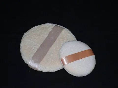 powder puff: a ball or pad of soft material used for the application of cosmetic powder to the face