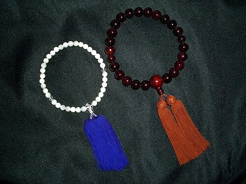 prayer beads: a string of beads used by members of various religions to count prayers, chants, or devotions