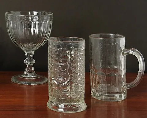 pressed glass: a form of glass made by a plunging molten glass into a mold to produce designs