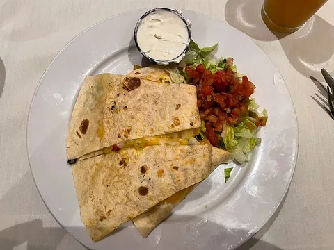 quesadilla: a Mexican dish made by filling a tortilla with cheese and sometimes other ingredients and then...