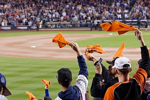 rally towel: a sports accessory, often a brightly colored towel with a team's logo, that fans wave at games to...