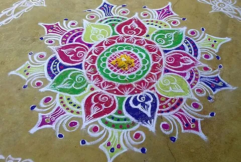 rangoli: a geometric or stylized design on the floor (or other flat surface) made using small coloured...
